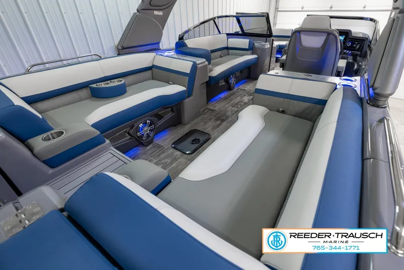 Slide: The Image of 2023 Avalon Waketoon boat interior with blue and white seating, modern design, and ambient lighting. - 13