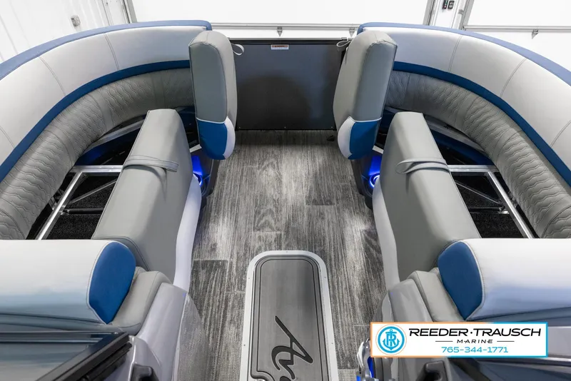 Slide: The Image of 2023 Avalon Waketoon boat interior with gray and blue seating, Reeder-Trausch Marine logo. - 24
