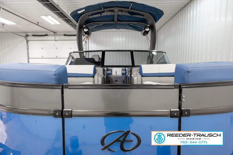 Slide: The Image of 2023 Avalon Waketoon boat in a showroom, rear view with blue seating. - 25