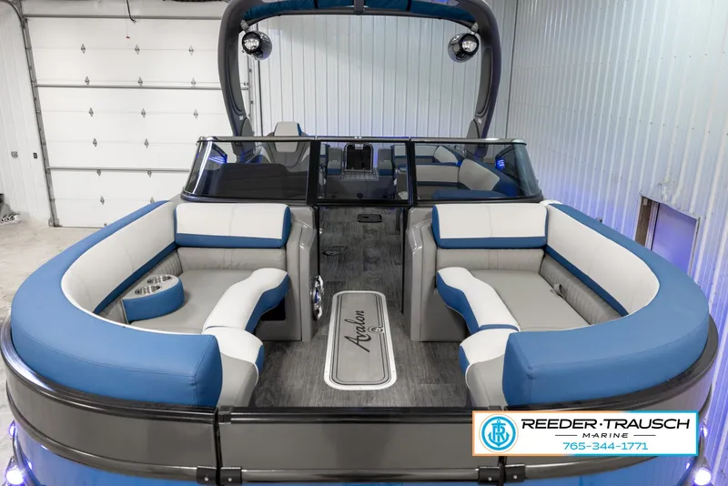 Slide: The Image of 2023 Avalon Waketoon boat interior with blue and white seating, displayed at Reeder-Trausch Marine. - 26