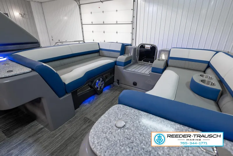 Slide: The Image of 2023 Avalon Waketoon boat interior with blue and gray seating, showcased by Reeder-Trausch Marine. - 34