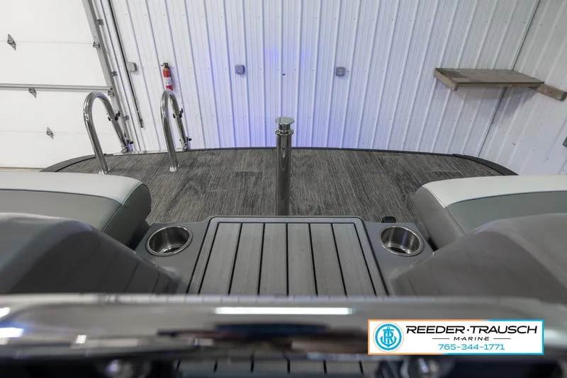 Slide: The Image of 2023 Avalon Waketoon boat interior with seating and cup holders in a showroom. - 38