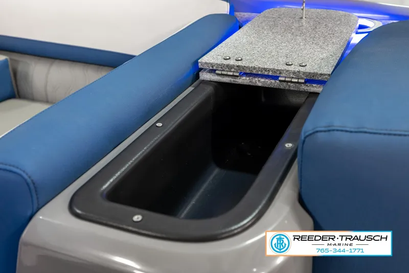 Slide: The Image of 2023 Avalon Waketoon boat storage compartment with blue seating and Reeder Trausch Marine logo. - 43