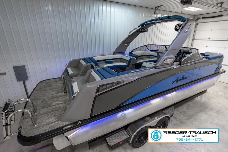 Slide: The Image of 2023 Avalon Waketoon boat in showroom, blue and gray design, Reeder-Trausch Marine. - 6