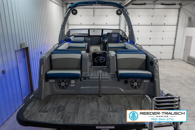 Slide: The Image of 2023 Avalon Waketoon boat interior with seating and speakers in a garage. - 8