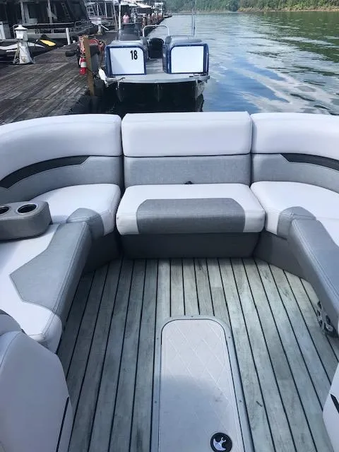 Slide: The Image of 2018 Crest Caliber boat with spacious seating at a dock. - 2