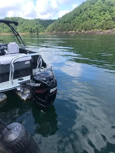 Slide: The Image of 2018 Crest Caliber boat with Mercury 200 outboard motor on a serene lake. - 6