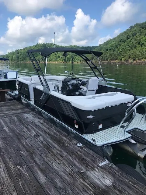 Slide: The Image of 2018 Crest Caliber boat docked on a serene lake with lush green hills. - 7