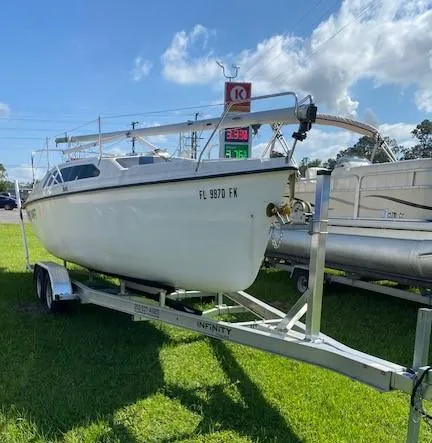 The Image of 1993 Hunter 23.5 sailboat on trailer at a gas station. - 1