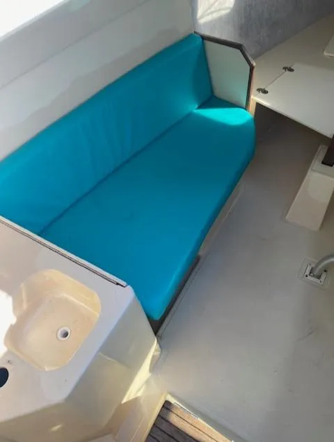 Slide: The Image of Interior of a 1993 Hunter 23.5 sailboat with blue seating and a small sink. - 7
