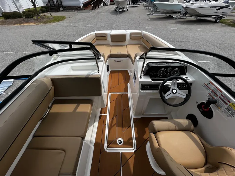 Slide: The Image of 2024 Bayliner DX2000 boat interior with tan seating and modern dashboard. - 11