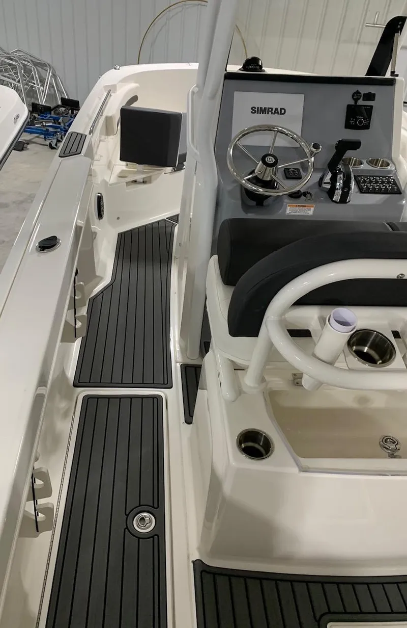 Slide: The Image of 2024 Bayliner Trophy 24 CC center console boat interior with steering wheel and controls. - 9