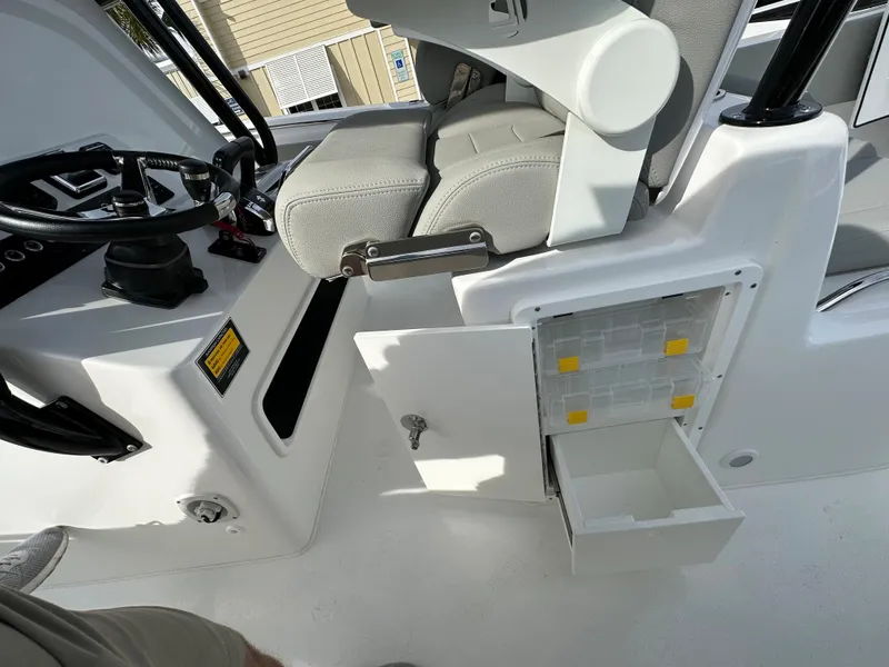 Slide: The Image of 2024 Cape Horn 32 XS boat interior with storage compartment and helm seat. - 21