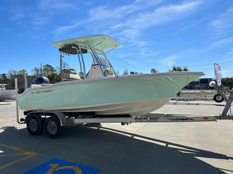 Slide: The Image of 2024 Key West 219 FS boat on a trailer in a parking lot. - 2