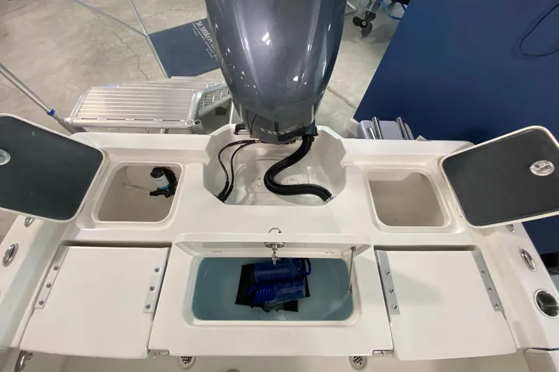 Slide: The Image of 2024 Key West 250 Bay Reef boat stern with storage compartments and outboard motor. - 17