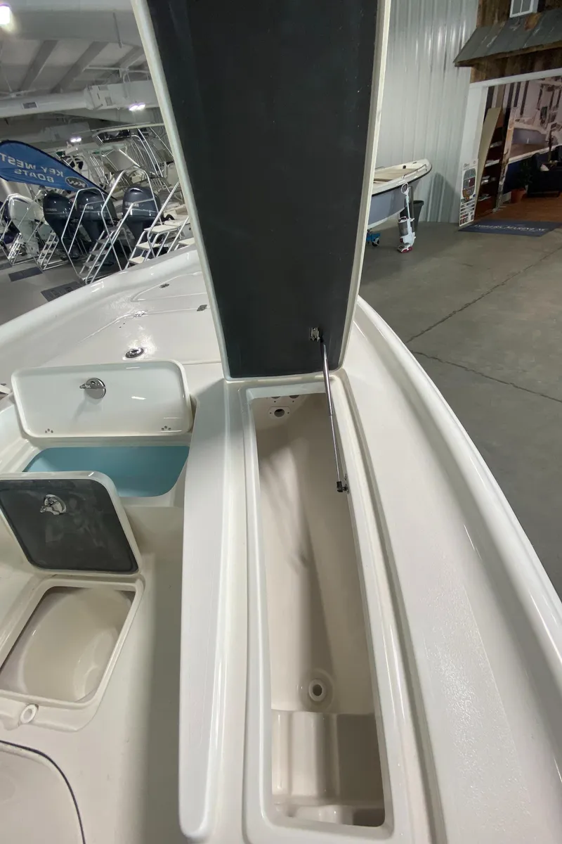 Slide: The Image of 2024 Key West 250 Bay Reef boat storage compartment open in showroom. - 18