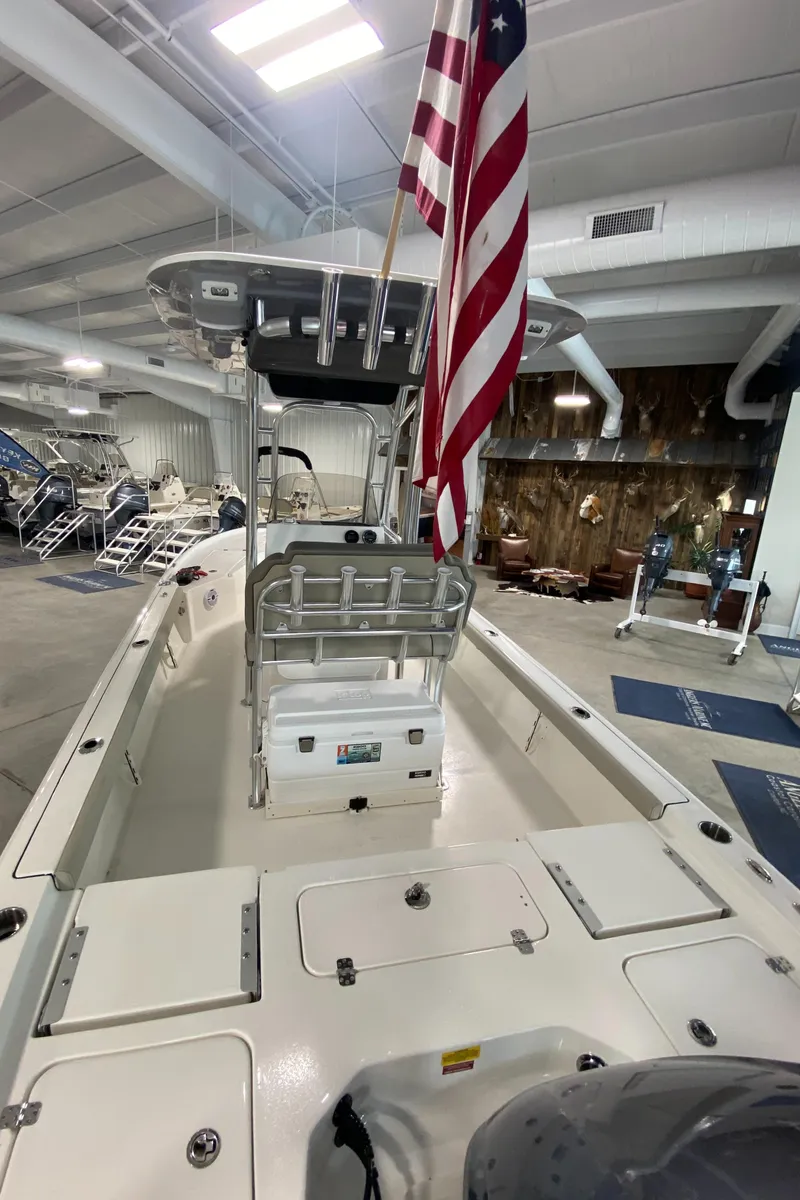 Slide: The Image of 2024 Key West 250 Bay Reef boat in showroom with American flag. - 6