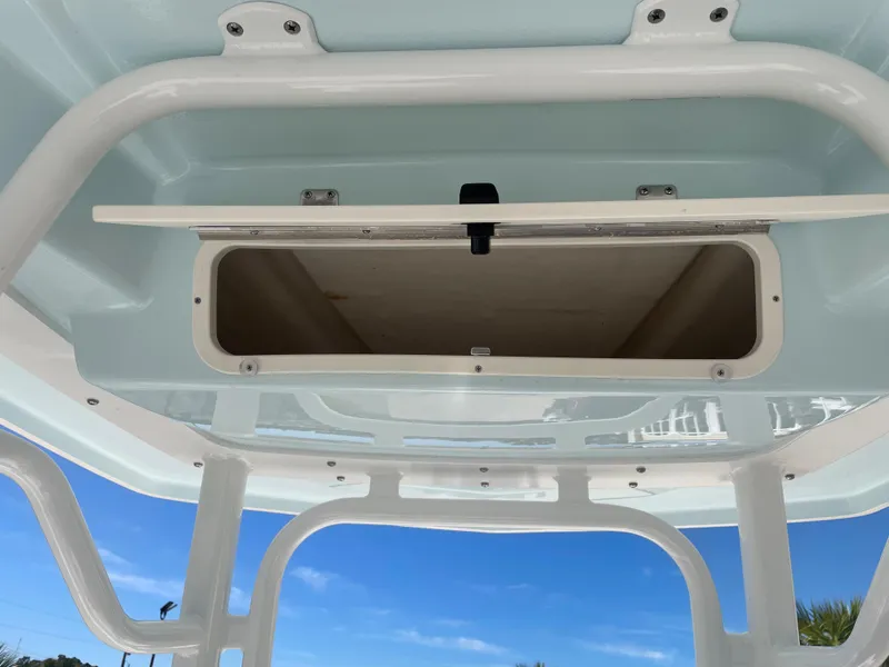 Slide: The Image of 2024 Robalo 226 Cayman boat storage compartment under blue sky. - 13