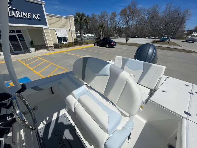 Slide: The Image of 2024 Robalo 226 Cayman boat with white and gray seating at a marine dealership. - 16