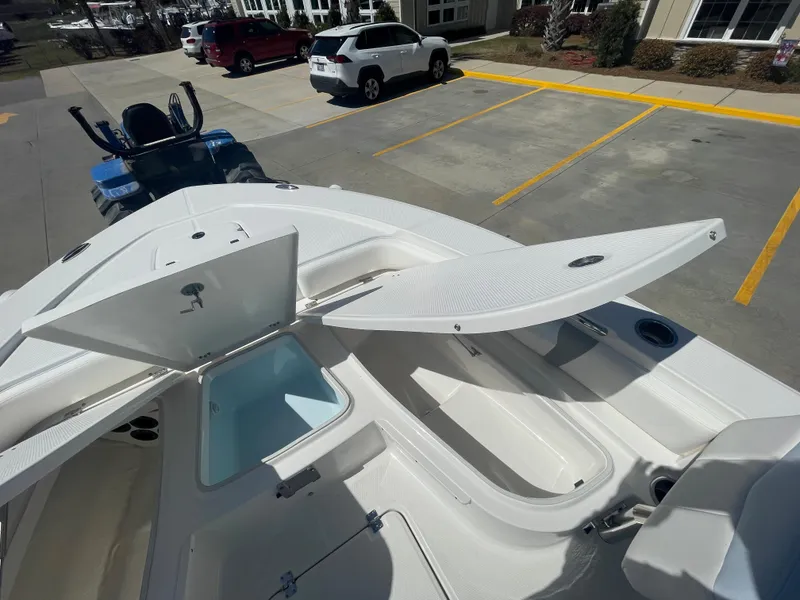 Slide: The Image of 2024 Robalo 226 Cayman boat with open storage compartments in a parking lot. - 22