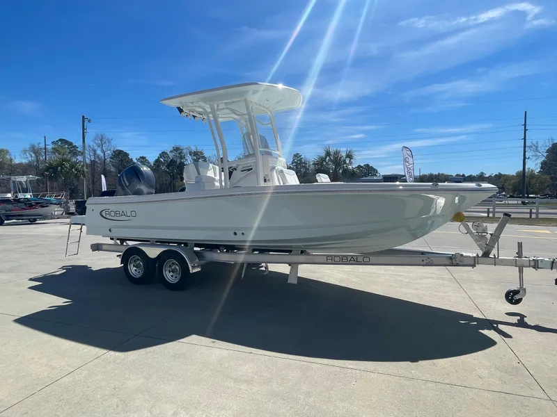 Slide: The Image of 2024 Robalo 226 Cayman boat on a trailer under a clear blue sky. - 5