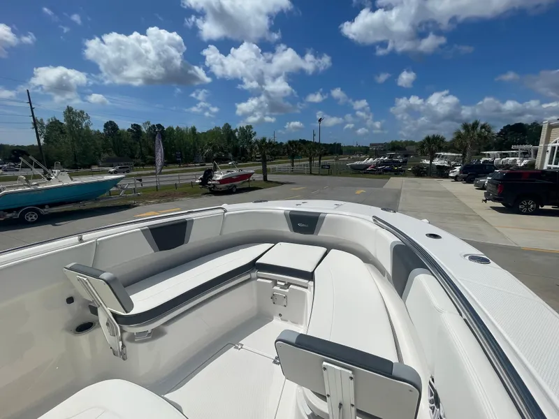 Slide: The Image of 2023 Robalo 270 boat interior with seating, docked under a blue sky. - 19