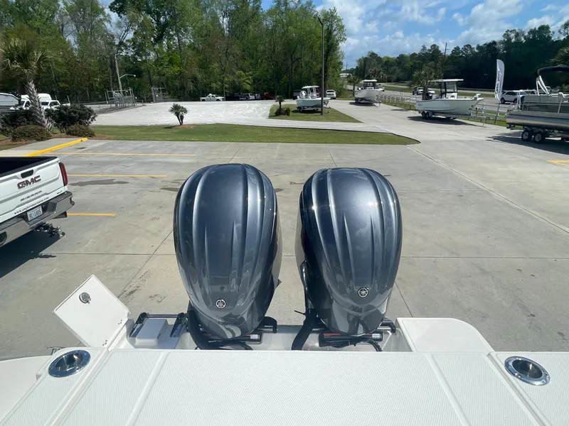 Slide: The Image of 2023 Robalo 270 boat with twin outboard engines in a marina. - 7