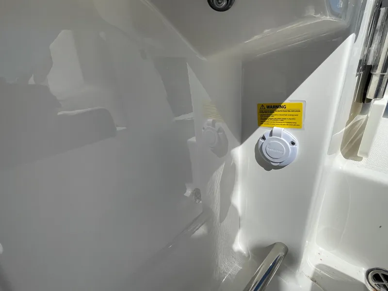 Slide: The Image of 2024 Robalo R222 Center Console interior detail with warning label and fixture. - 13