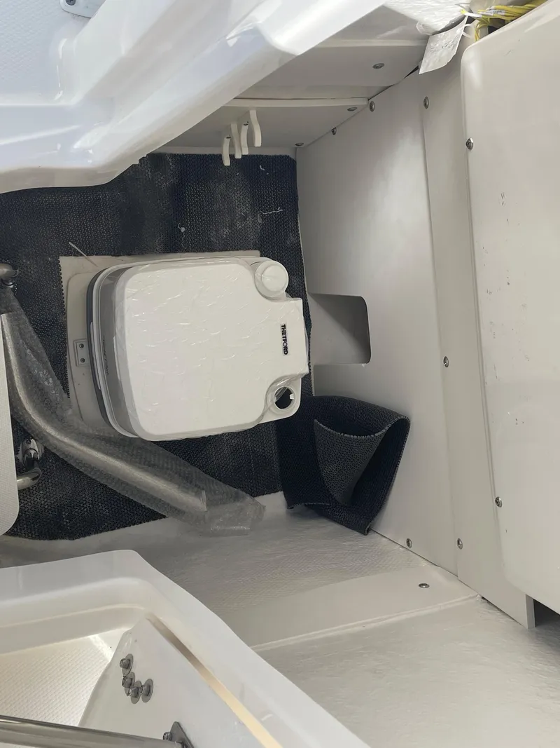 Slide: The Image of 2024 Robalo R222 Center Console boat interior with portable toilet. - 20