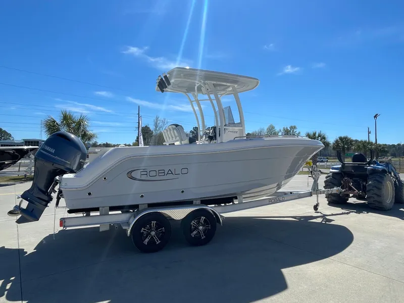 Slide: The Image of 2024 Robalo R222 Center Console boat on trailer under clear blue sky. - 3