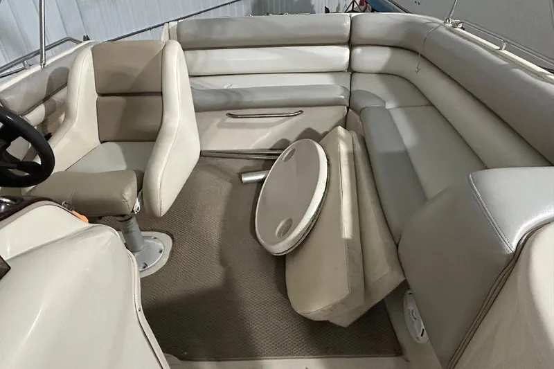 Slide: The Image of 2002 Larson Escape 213 boat interior with beige seating and steering wheel. - 18