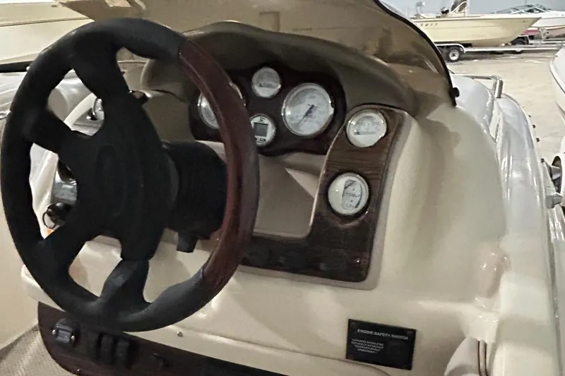 Slide: The Image of 2002 Larson Escape 213 boat dashboard with steering wheel and gauges. - 19