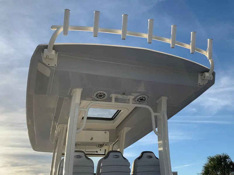 Slide: The Image of 2024 Robalo R360 boat with rod holders and seating under a clear sky. - 5