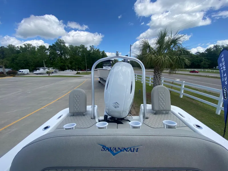 Slide: The Image of 2024 Savannah SS21 boat with outboard motor, cup holders, and scenic background. - 4