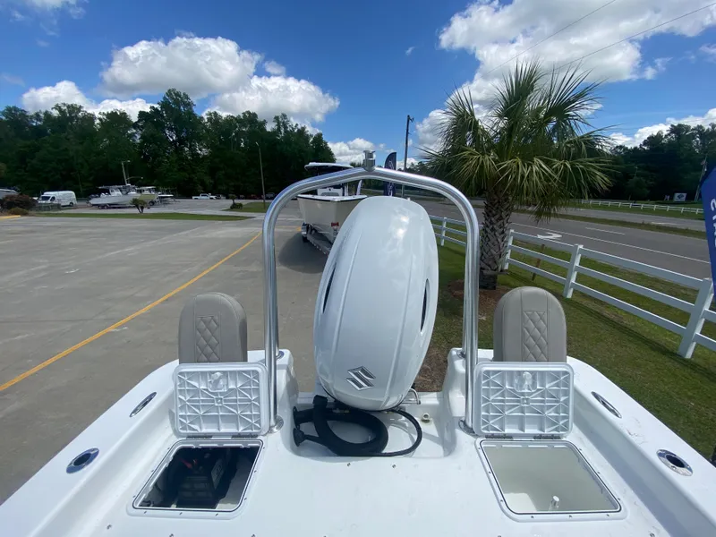 Slide: The Image of 2024 Savannah SS21 boat with outboard motor, parked near palm tree and road. - 5