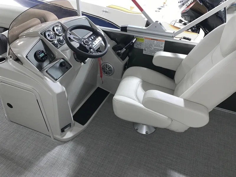 Slide: The Image of 2024 Starcraft EX22 FD boat cockpit with steering wheel and captain's chair. - 6