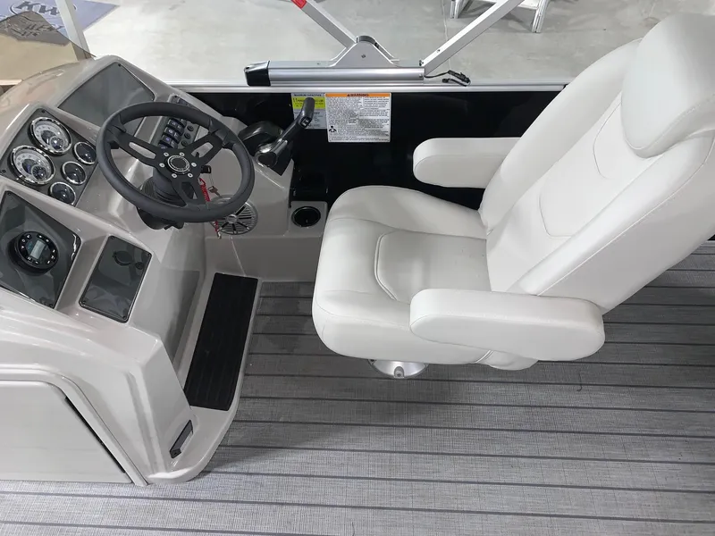 Slide: The Image of 2024 Starcraft EX22 FD boat cockpit with steering wheel and captain's chair. - 10