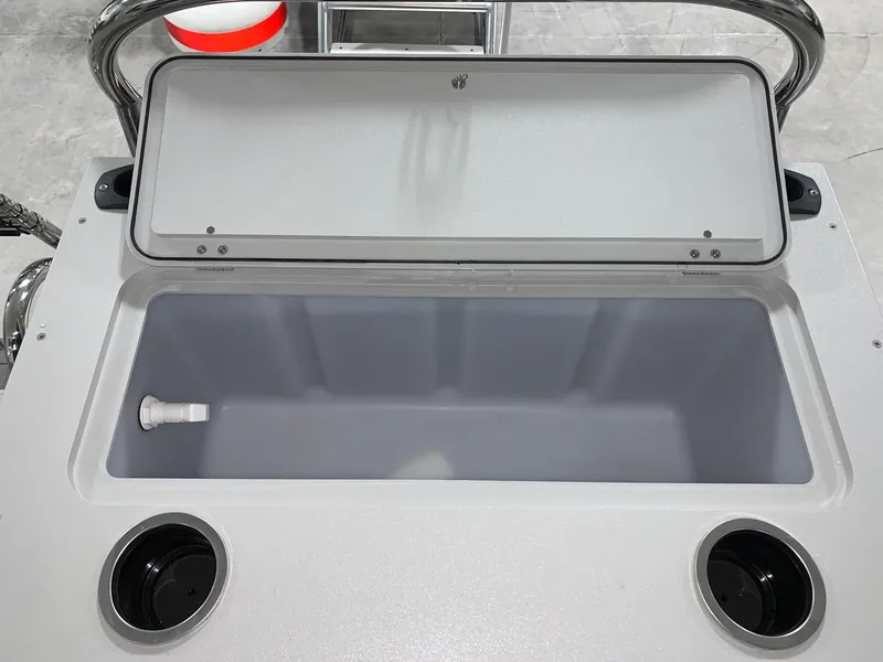 Slide: The Image of 2024 Starcraft EX22 FD boat storage compartment with open lid and cup holders. - 5