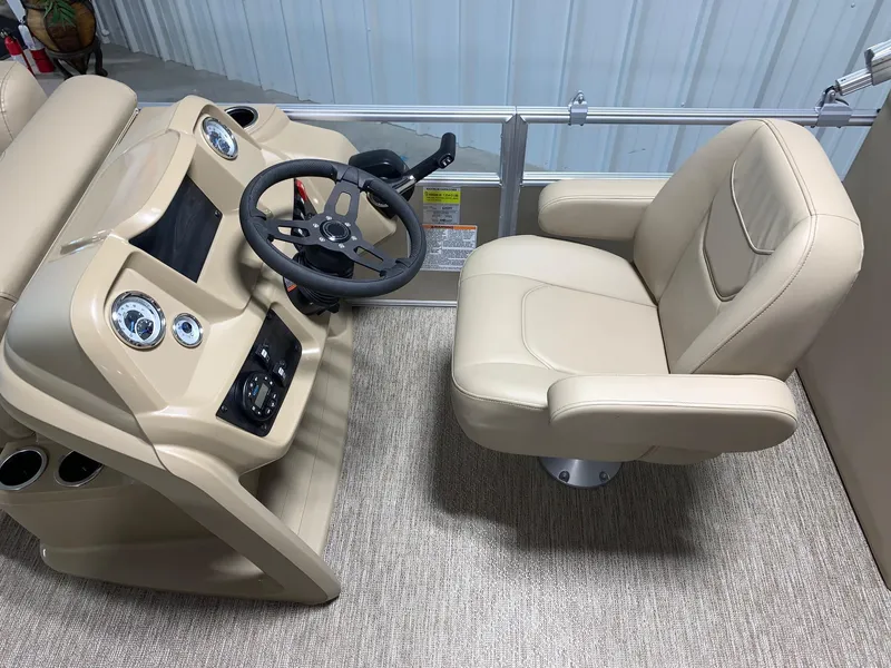 Slide: The Image of 2024 Starcraft LX22 R boat helm with beige captain's chair and steering console. - 11