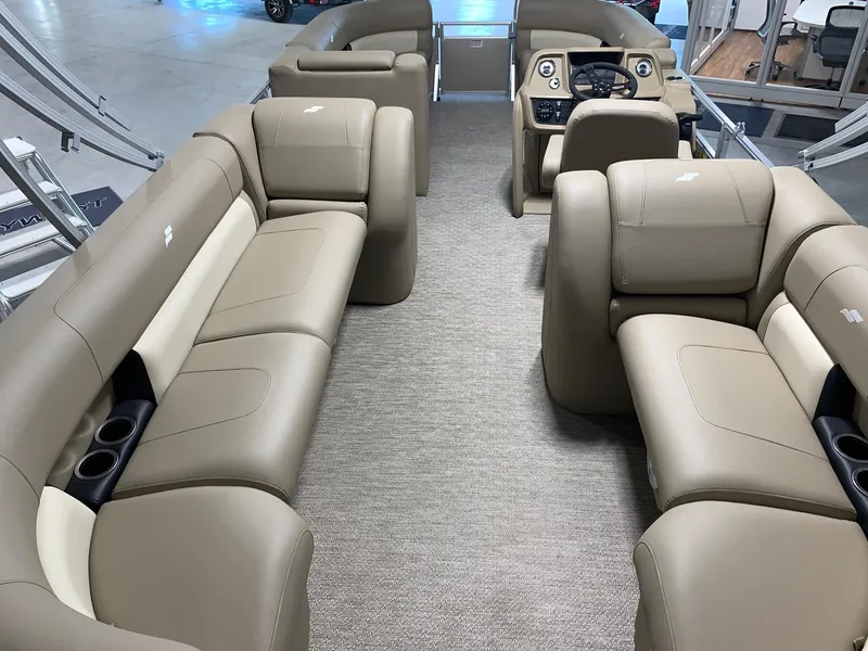 Slide: The Image of 2024 Starcraft LX22 R pontoon boat interior with beige seating and modern dashboard. - 6