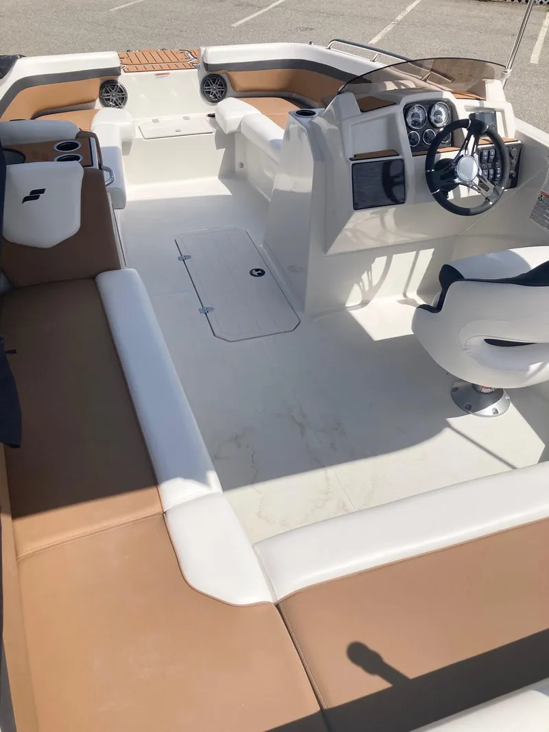 Slide: The Image of 2024 Starcraft SVX 191 boat interior with tan and white seating, steering console, and cup holders. - 14
