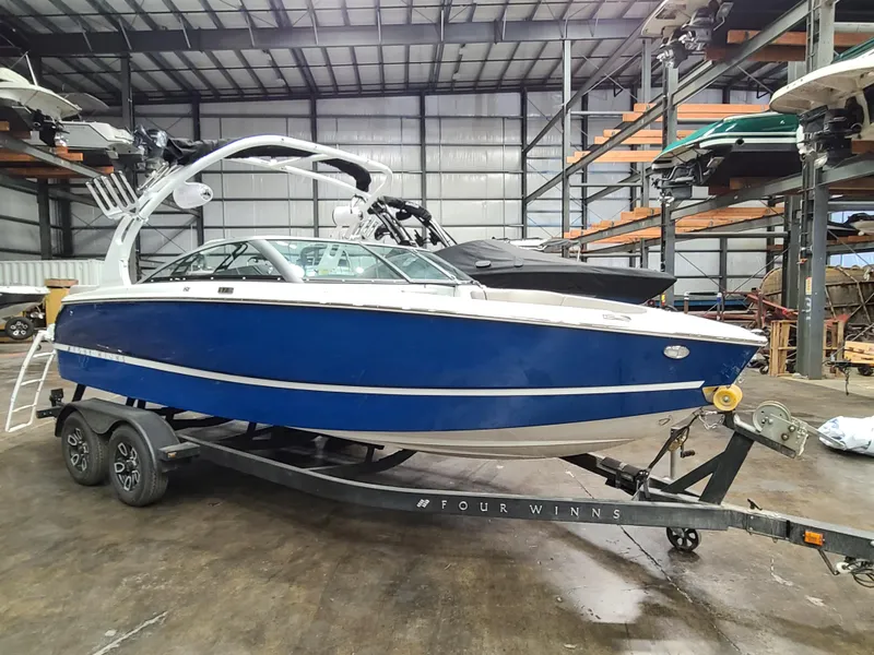 The Image of 2023 Four Winns H2 boat in blue on a trailer in a storage facility. - 0