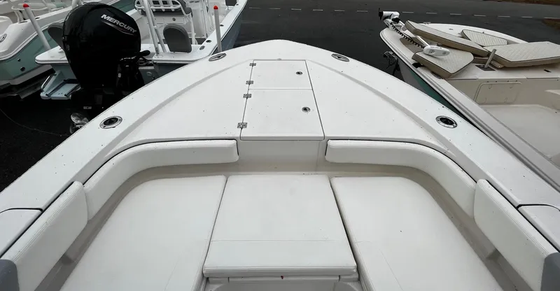 Slide: The Image of 2024 Robalo 266 Cayman boat bow with cushioned seating and storage compartments. - 16