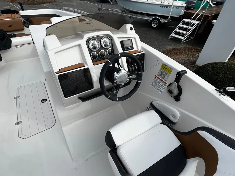 Slide: The Image of 2024 Starcraft SVX 231 boat cockpit with steering wheel and control panel. - 8