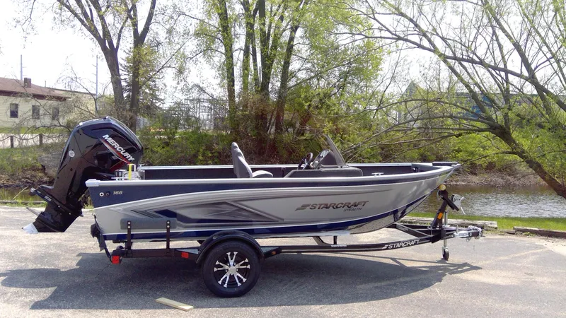 Slide: The Image of 2023 Starcraft Stealth 166 SC fishing boat on trailer by riverside. - 0