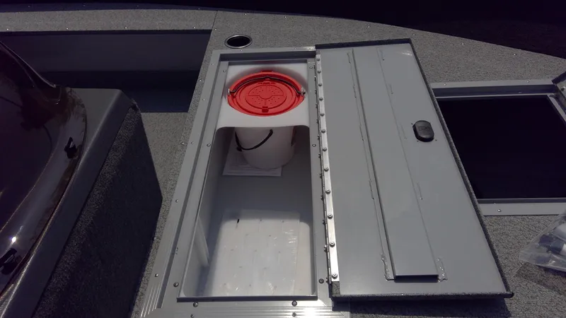 Slide: The Image of 2023 Starcraft Stealth 166 SC boat storage compartment with red lid bucket. - 10