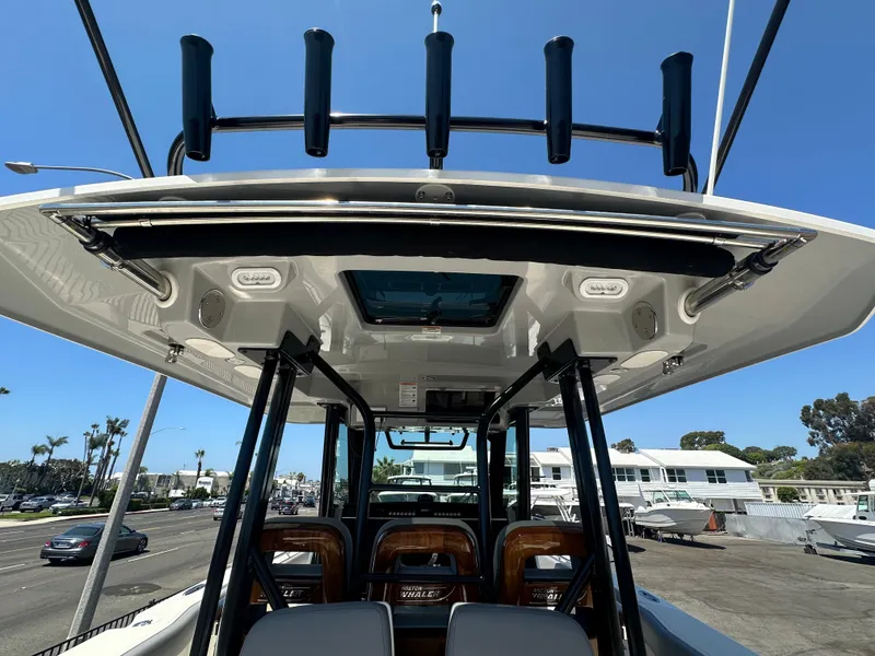 Slide: The Image of 2025 Boston Whaler 360 Outrage boat, view of helm and seating area under clear blue sky. - 10