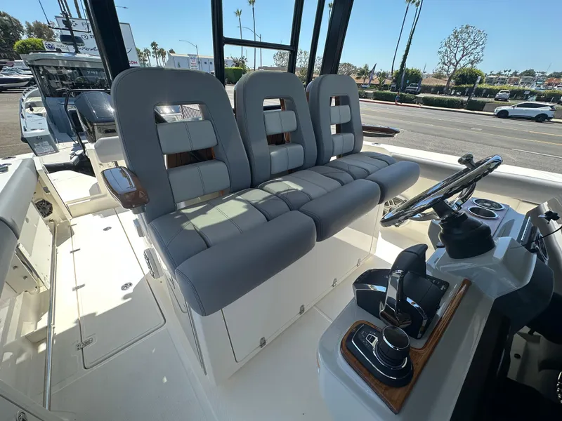 Slide: The Image of 2025 Boston Whaler 360 Outrage boat interior with modern seating and control panel. - 13