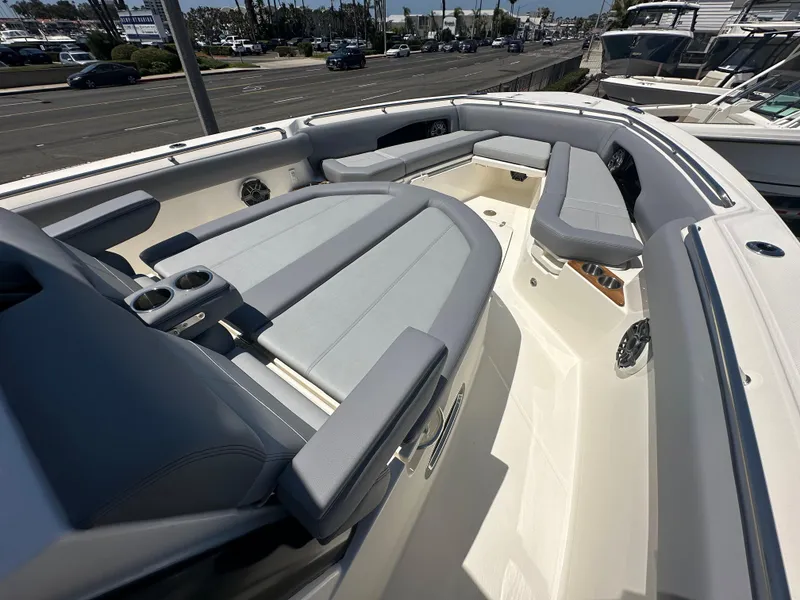 Slide: The Image of 2025 Boston Whaler 360 Outrage boat interior with gray seating and cup holders. - 14