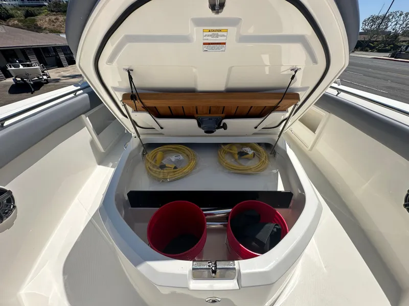 Slide: The Image of 2025 Boston Whaler 360 Outrage storage compartment with buckets and coiled ropes. - 17